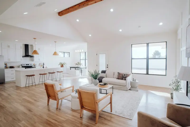 Pièce de vie rénovée et lumineuse : parquet clair, murs blancs, cuisine ouverte