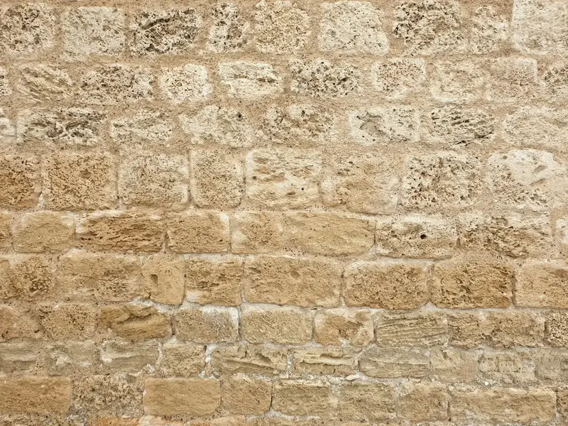 Mur ancien en moellons de calcaire blond aux joints de mortier, photographié de face